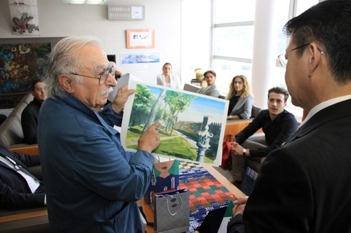 自分で描いたリエティ市の「伊東公園」の絵を小野市長（右）にプレゼントするブッチョーニさん＝伊東市役所