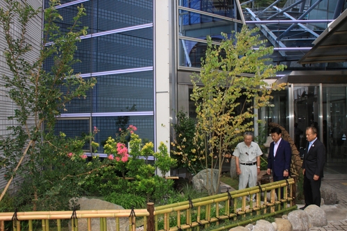 完成した日本庭園について立木会長（左）から説明を受ける小野市長（中）と稲葉富士憲議長＝市役所