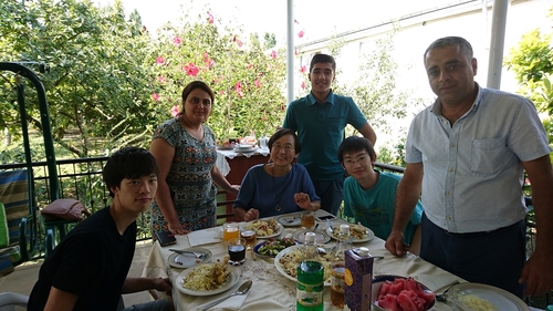 ホームステイ先で食事を楽しむ派遣学生の鈴木君（左手前）と梅原さん（右から２番目）＝アゼルバイジャン・イスマイリ州