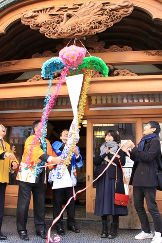 くす玉を割って祝う野崎さん（右から２人目）ら＝東海館