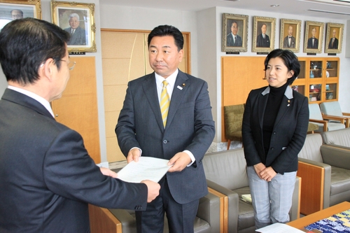 要望書を提出する杉本代表（中）と犬飼氏（右）＝市役所