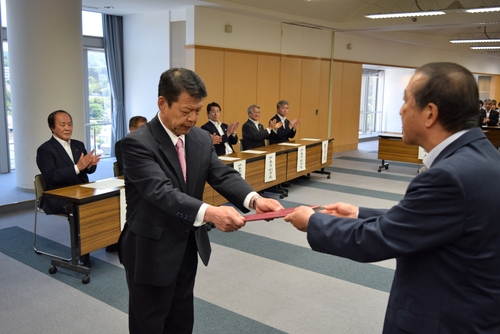 菊間委員長（右）から当選証書を受け取る小野氏＝市役所