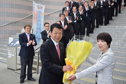 初登庁で女性職員から花束を手渡される小野市長＝市役所