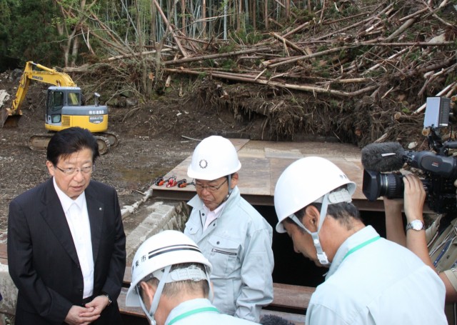 台風１５号の災害現場で担当者の説明を聞く川勝知事（左）＝伊東市池