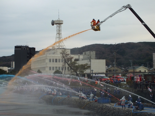 一斉に放水する消防団員たち＝渚町の藤の広場前