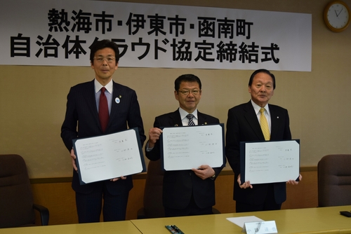 協定書を手に写真撮影に応じる斉藤市長、小野市長、仁科町長（左から）＝伊東市役所