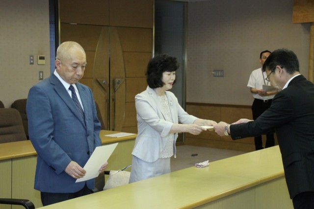 小野市長（右）から委嘱状を受け取る三浦さん（中）と富永さん＝伊東市役所