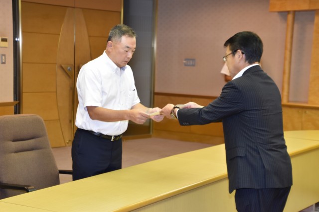 小野市長（右）から辞令を受け取る山本さん＝伊東市役所