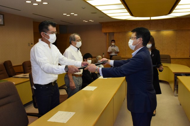 小野市長から市長感謝状を手渡される湯川区連合町内会の代表（左）＝伊東市役所