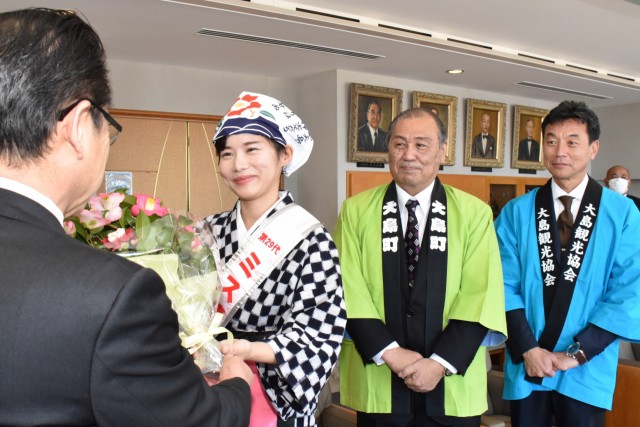 小野市長にツバキの花束を手渡す鈴木さん（左から２人目）＝伊東市役所