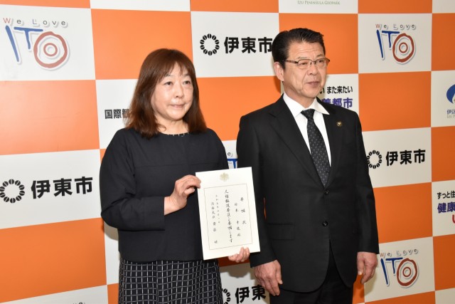 委嘱状を持って小野市長と記念撮影する鈴木さん（左）＝伊東市役所